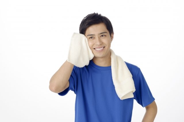 タオルで汗を拭く男性